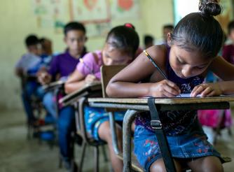 Students at the San Juan Villa Nueva School excitedly write their messages to their sponsors in the UK during Action Aid's annual message collection, 